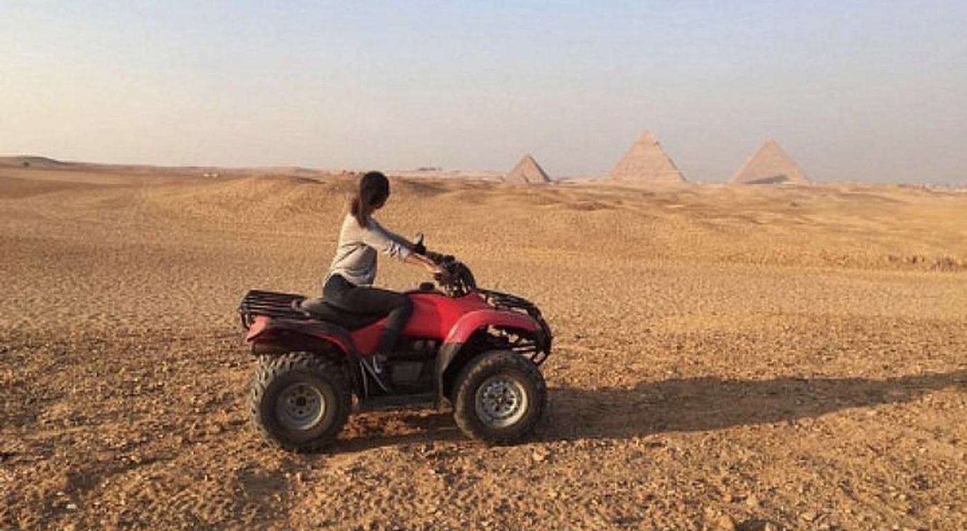 Quad bike in the desert with the Giza pyramids behind